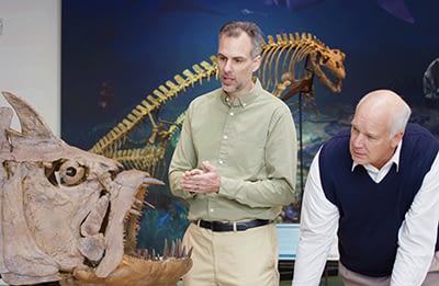 Dr. Marcus Ross (left) films a scene at Discovery Park of America (Tenn.) with host Dr. Del Tackett. The two are examining a skeleton of the extinct fish xiphactinus.
